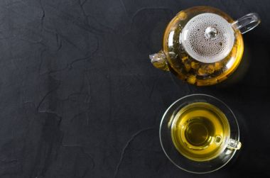 Fincan lezzetli bitkisel çay ve cam çaydanlık.