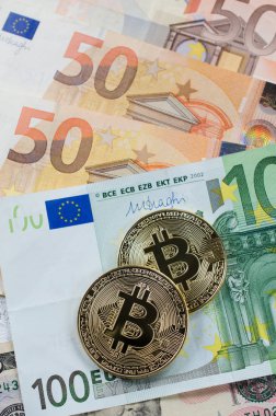 Euro banknot üzerinde iki altın bitcoins.