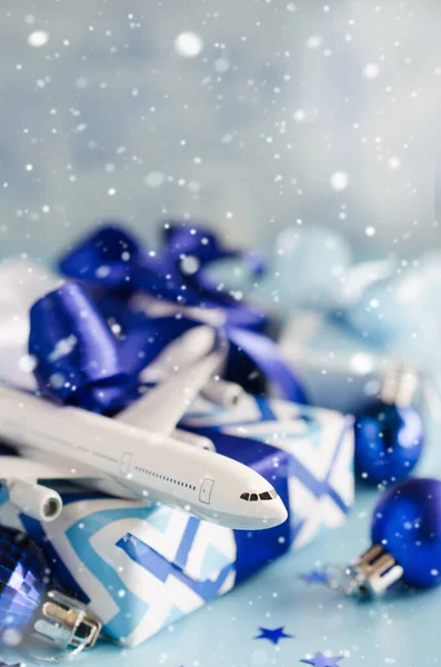 Concepto de viaje de Navidad o Año Nuevo. Avión de juguete con pasaportes y caja de regalo sobre fondo azul . — Foto de Stock