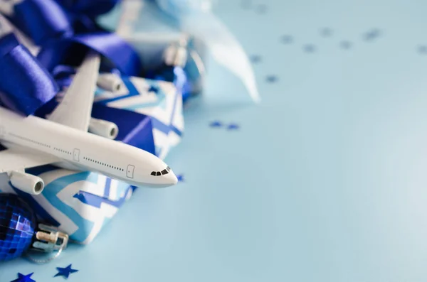 Концепція різдвяних або новорічних подорожей. Іграшковий літак з паспортами та подарунковими коробками на синьому фоні . Стокове Зображення
