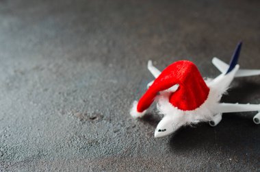 Noel ya da yeni yıl seyahati konsepti. Oyuncak uçak ve Noel Baba şapkası..