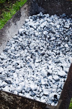 Barbeküde yanmış gri kömür. Piknik için şenlik ateşi. Yaz, güneşli bir gün..