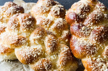 Fırında taze kokulu çörekler. Koyu arka planda geleneksel ev yapımı hamur işleri. Pigtail çörekler üst görünümü. Rustik tarz. Metniniz için alan kopyalama.