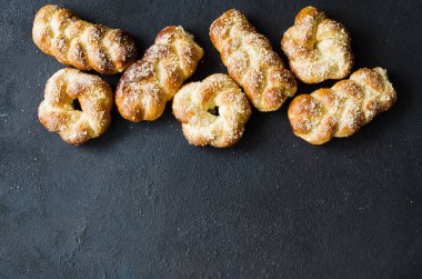 Fırında taze kokulu çörekler. Geleneksel ev yapımı hamur işleri. Pigtail çörekler üst görünümü. Rustik tarz. Metniniz için alan kopyalama.