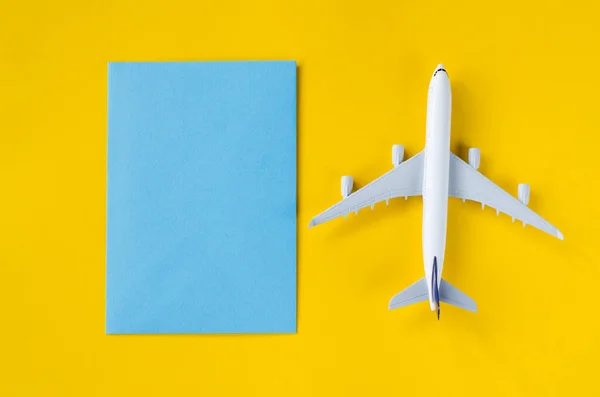Leeg blauw papier op gele achtergrond met decoratief vliegtuig. Zomerreisconcept. — Stockfoto