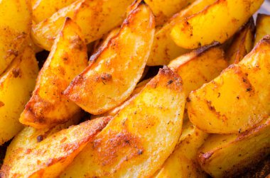 Altın baharatlı patatesler kızartılmış ya da yakın plan fırında pişirilmiş. Köy tarzında lezzetli, lezzetli, çıtır çıtır atıştırmalıklar. Üst görünüm.