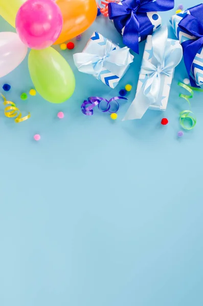 Parti ya da doğum günü mavi arka planı. Tatil maketi. Kopya alanı olan tebrik kartı. Renkli balon, hediye kutuları ve yılan yağıyla çerçevelenmiş. Üst Manzara. Düz yatıyordu.