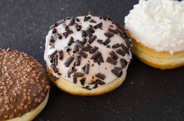 Geleneksel çörek günü. Beton arka planda çikolata kaplı çeşitli çörekler. Üst görünüm