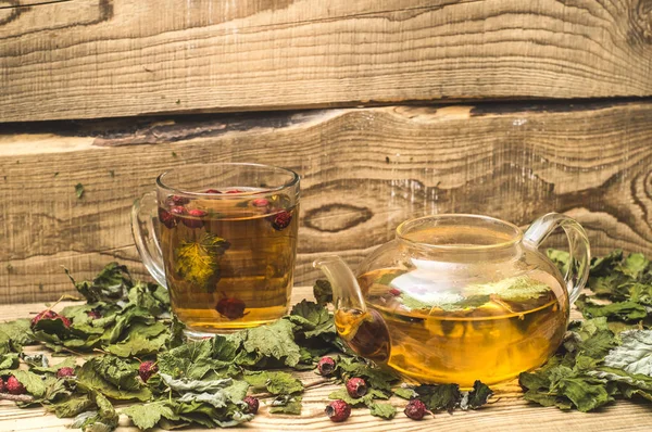 Transparent kettle and a mug with hot herbal tea — Stock Photo, Image