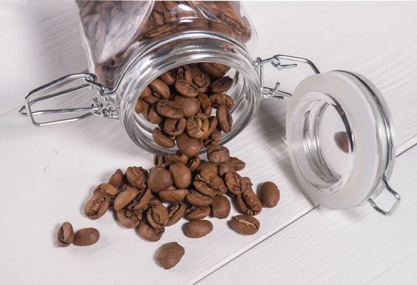 Die Streuung von Kaffeebohnen maragogype von transparenten Banken — Stockfoto