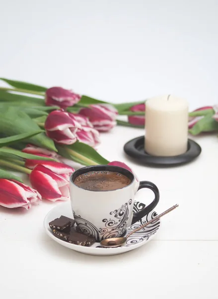 Coffee and candle in pink tulips — Stock Photo, Image