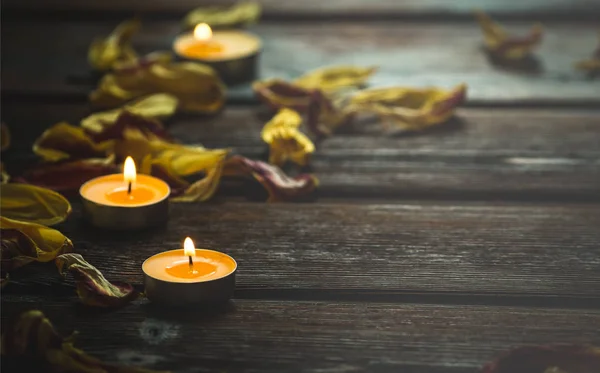 노란 촛불 및 말린된 꽃 꽃잎 — 스톡 사진