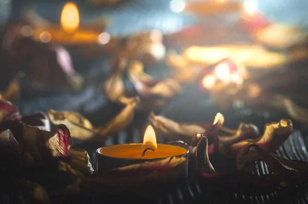 Velas amarelas e plamennoi cercado por pétalas secas de tulipas — Fotografia de Stock