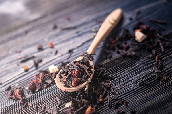 Las hojas de té de frutas en cucharas de madera — Foto de Stock