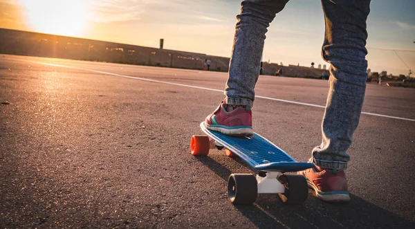 Close-up van de voeten op het skateboard op de stoep — Stockfoto