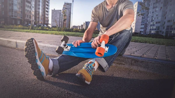 Man met een skateboard zit — Stockfoto