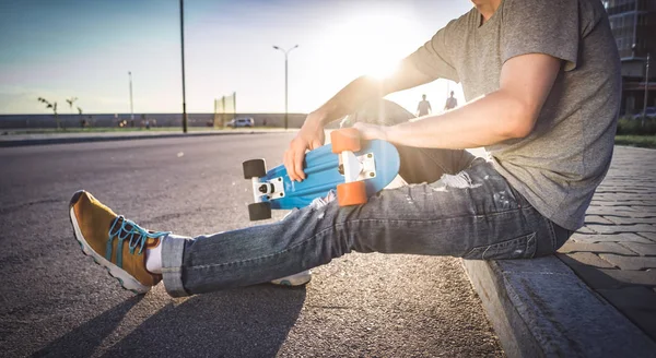 Man met een skateboard zit — Stockfoto