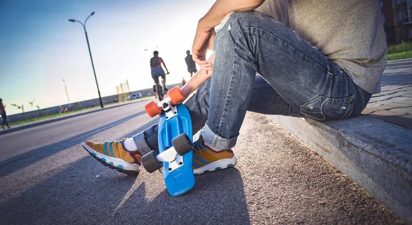 Man met een skateboard zit — Stockfoto
