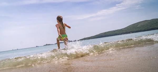 海岸の緑の水着の女の子を実行します。 — ストック写真