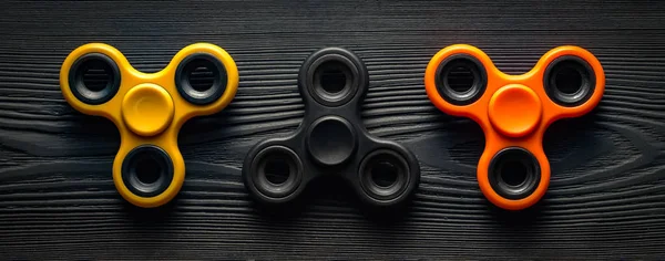 orange, yellow and black spinners on a black background