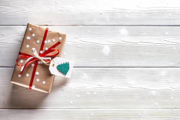 Karácsonyi ajándék hópelyhek fehér alapon piros szalaggal — Stock Fotó