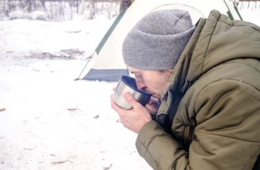 turist kış ormanda sıcak çay içer