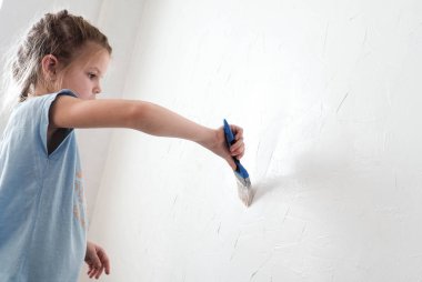 Kız bir fırça ile oda duvar boyaları