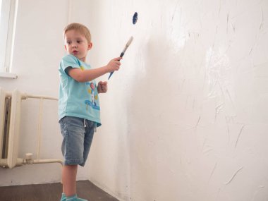 Çocuk bir rulo ile oda duvar boyaları