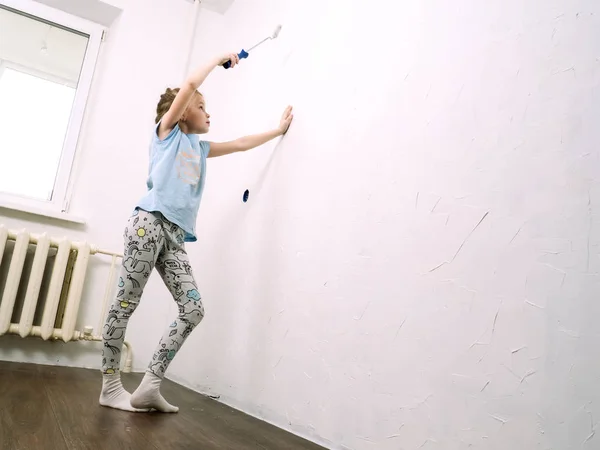 La chica pinta la pared de la habitación con un rodillo —  Fotos de Stock