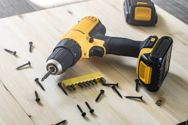 ahşap bir masa, vida, bit bir dizi üzerinde sarı tornavida.