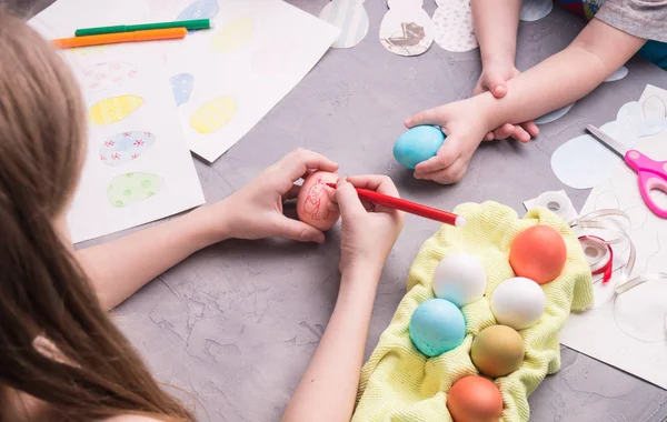 Förbereda för att fira påsk: flickan gör en ritning på Easter egg. — Stockfoto