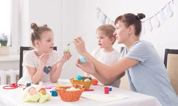 Familj semester påsk: Mamma hjälper sin dotter att måla ett påskägg. — Stockfoto