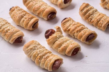 ev yapımı hamur işleri: beyaz zemin üzerinde bir hamur içinde birkaç sosis.