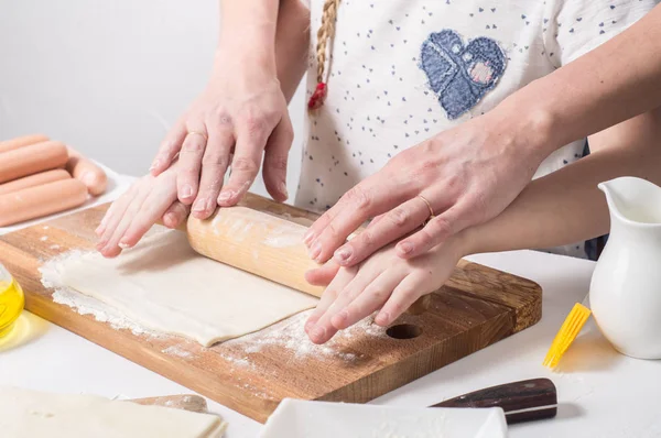 Home Food: Mom and daughter roll out dough.