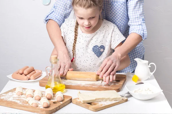 Home Food: Mom and daughter roll out dough.