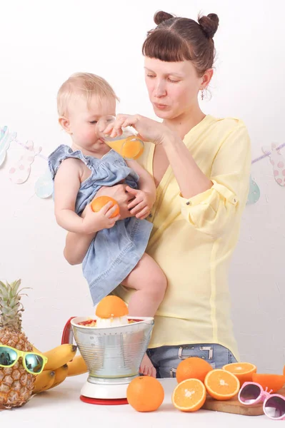 Healthy food for children: Mom treats her daughter with fresh orange juice.