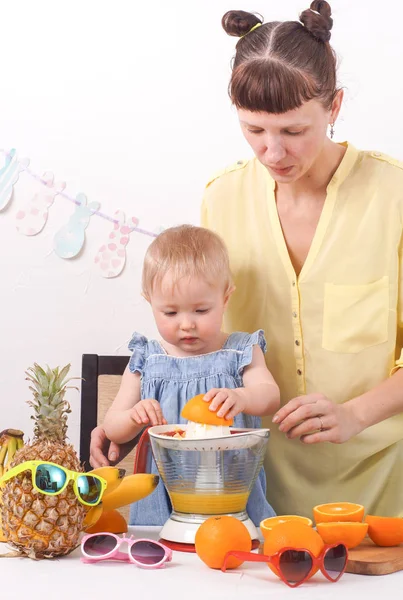Healthy food for children: Mom and daughter make fresh orange juice