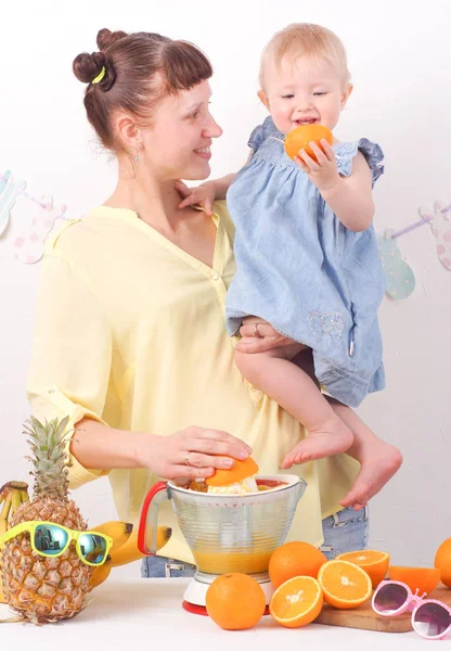 Gesundes Essen für Kinder: Mutter und Tochter machen frischen Orangensaft — Stockfoto