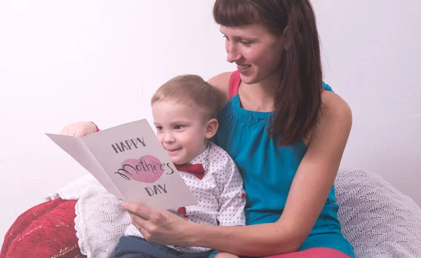 Glücklicher Muttertag: Mutter und Sohn lesen eine Postkarte. — Stockfoto