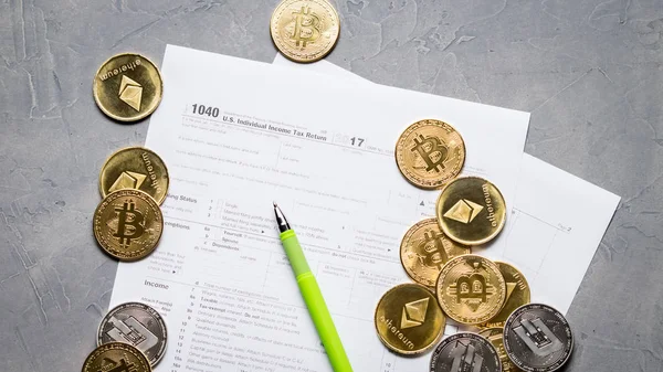 Cripto moneda: Páginas del formulario de impuestos 1040 y una dispersión de monedas bitcoin, etéreo . — Foto de Stock