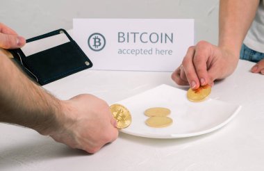 Kripto bir para birimi satın almak için ödeme: alıcı metal paralar bitcoin para tabakta koyar. Satıcı sikkeler toplayan.