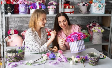 İki kız, yaklaşan bayram için sepetlerde bir buket gül topluyor..