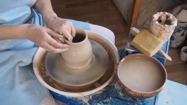 Girl Potter esculpe una jarra de arcilla en una rueda Potters . — Vídeos de Stock