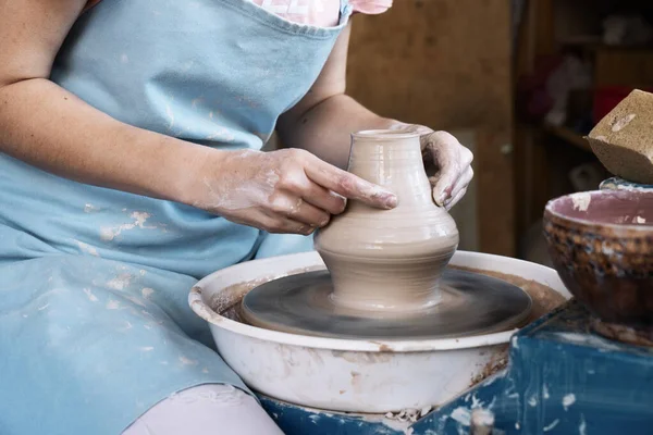Girl Potter esculpe una jarra de arcilla en una rueda Potters . — Foto de Stock