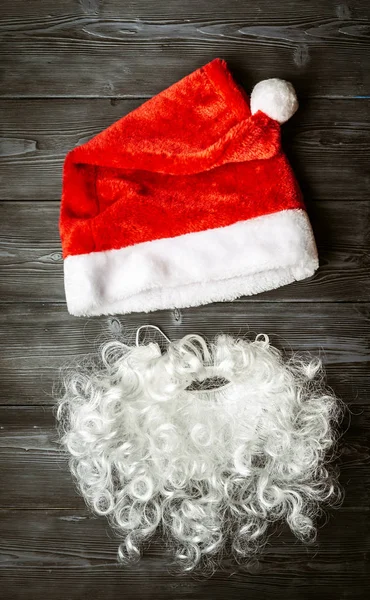 Red Santa Claus hat on a dark wooden background. — Stockfoto