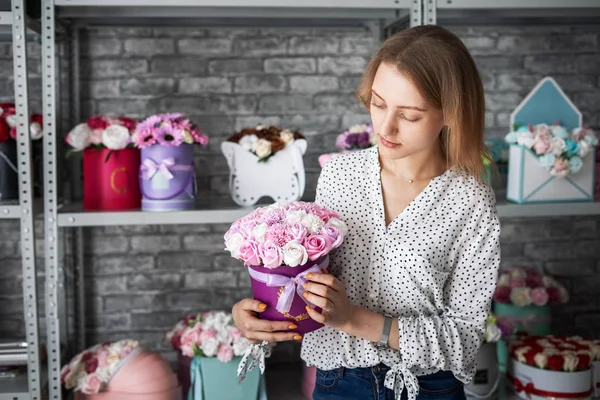 Chica joven con un ramo de rosas marrones y rosas blancas en una florería . — Foto de Stock