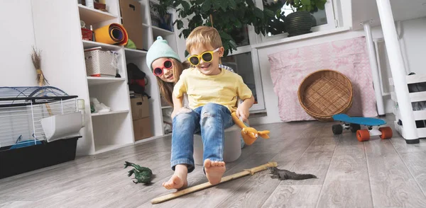 Çocuklar eğlenir ve beyaz plastik bir kutuda ata binerler. Oda darmadağın..