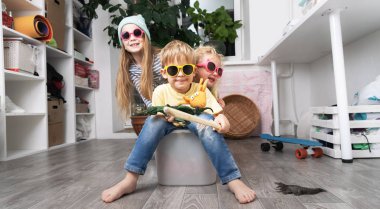 Çocuklar eğlenir ve beyaz plastik bir kutuda ata binerler. Oda darmadağın..