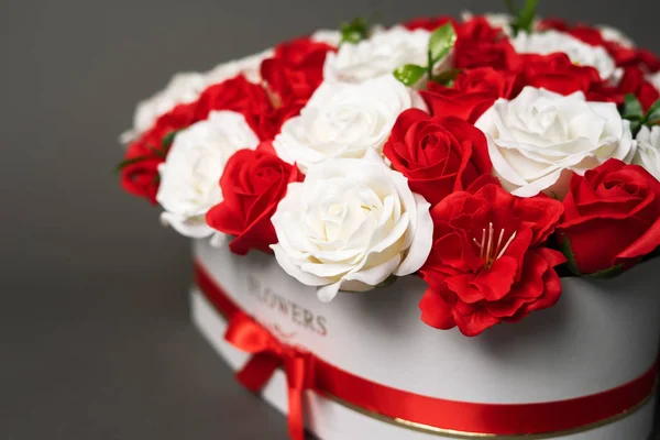 Kwiaty w rozkwicie: Bukiet czerwonych i białych róż na szarym tle. — Zdjęcie stockowe