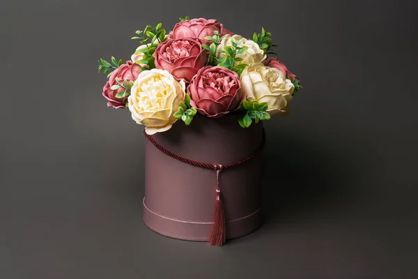 Flores en flor: Ramo de peonías rosas en una caja rosa sobre un fondo gris . — Foto de Stock